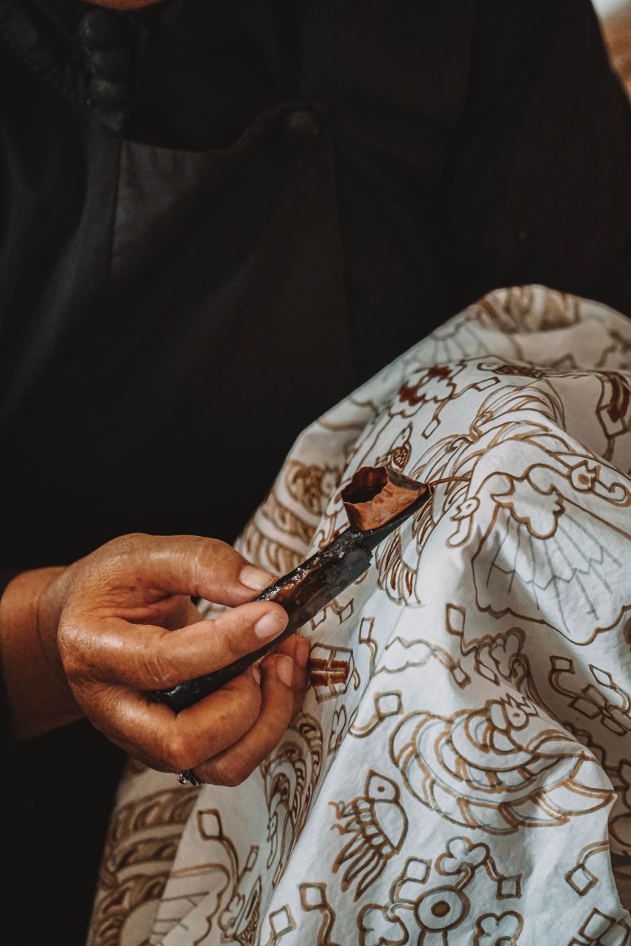 Batik wax being applied with a canting tool