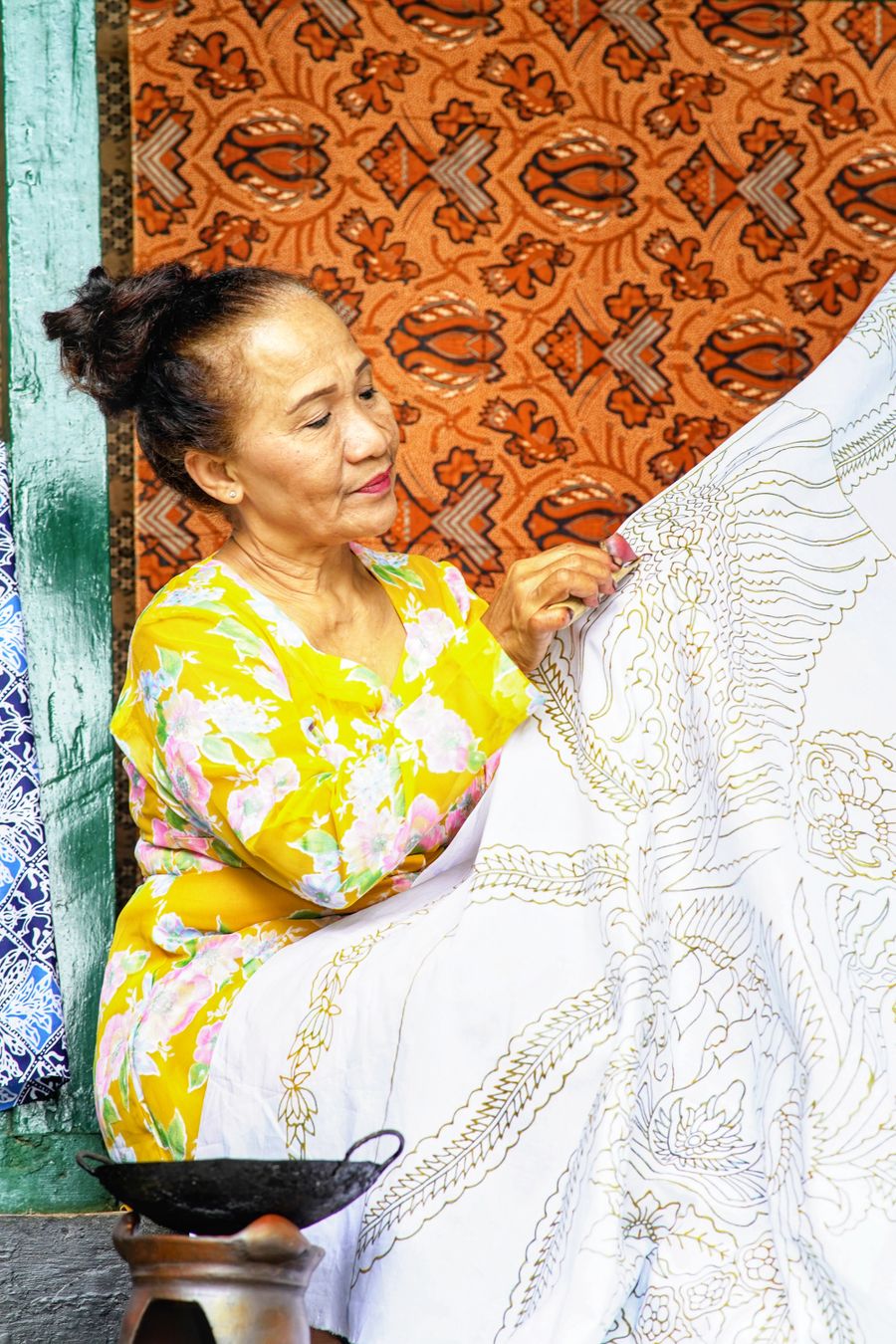 An artisan checking her batik work